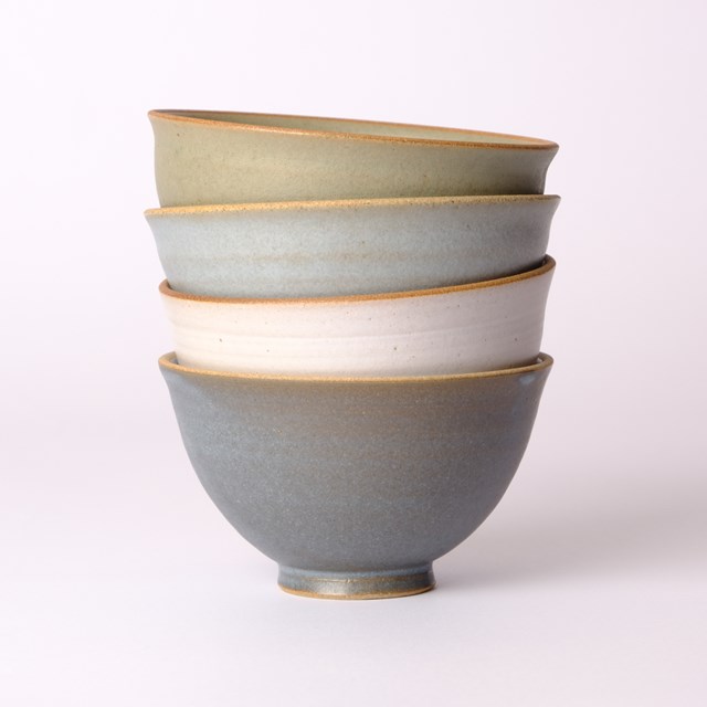 Four stacked stoneware bowls in sage, blue, white and slate glazes
