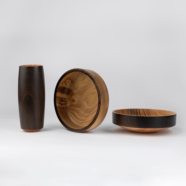 Three turned wooden vessels in dark and pale wood